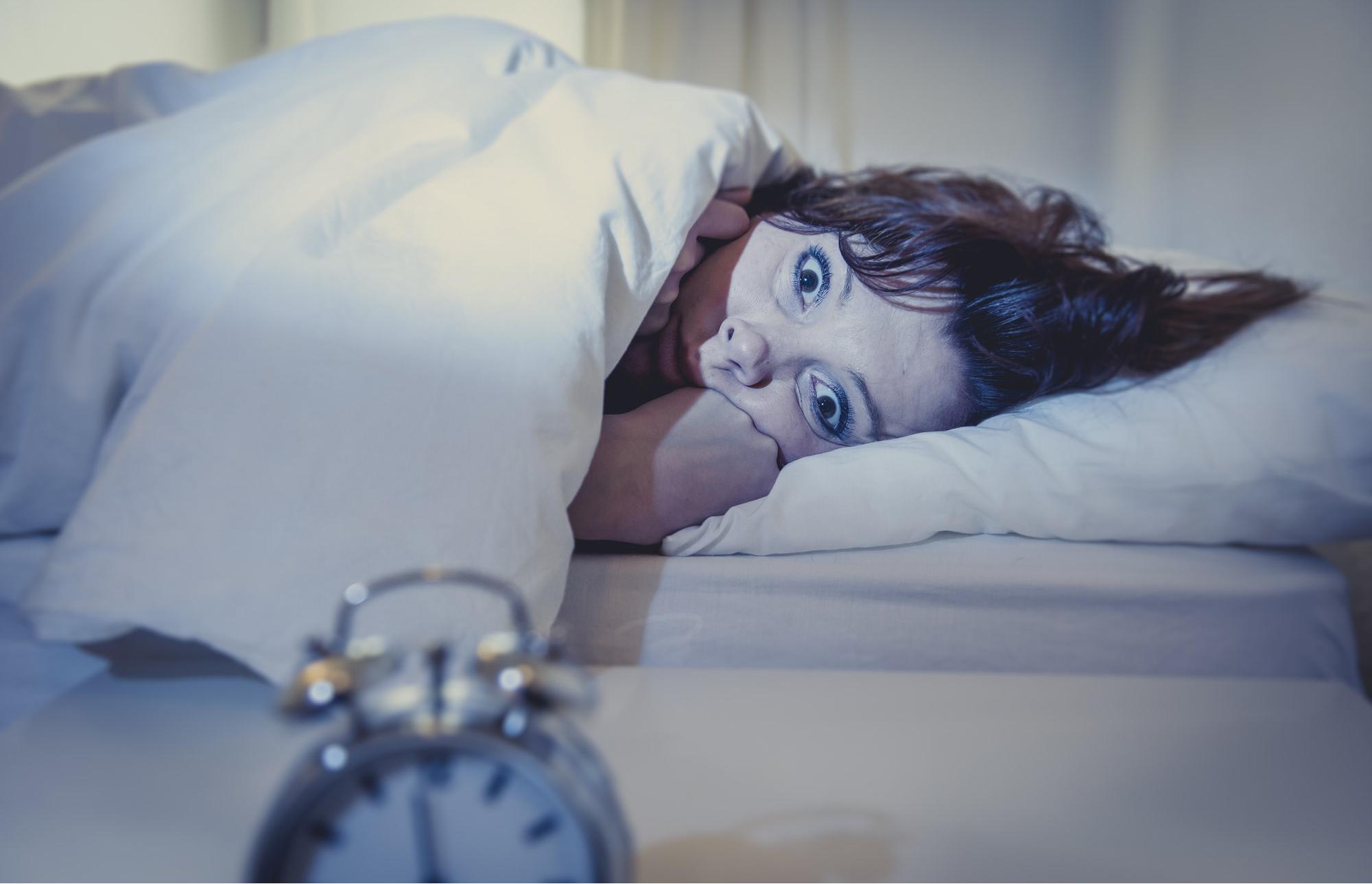 person in bed with eyes open