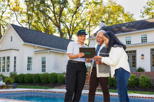 Terminix rep speaking with customers next to a pool
