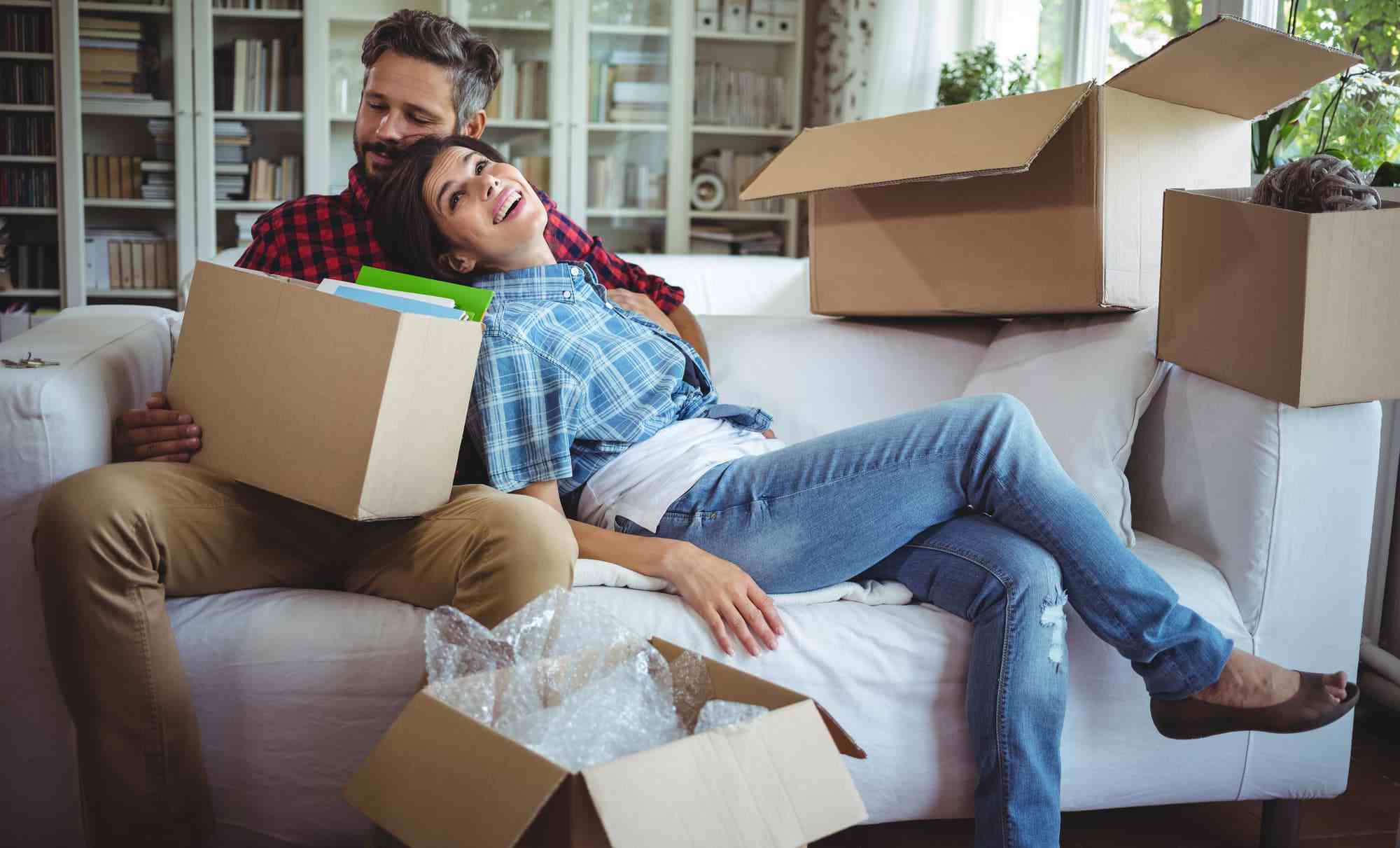 couple sitting on couch after moving in